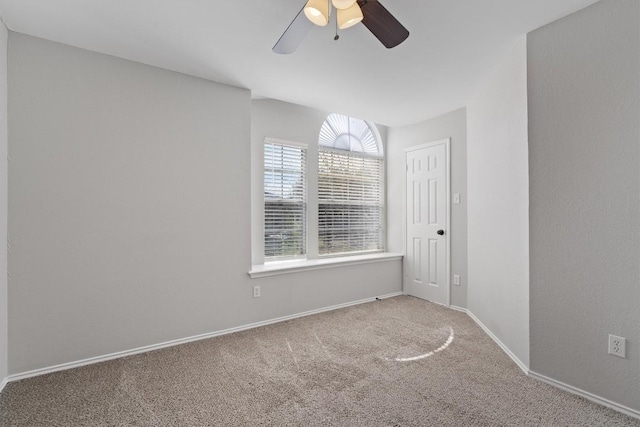 spare room featuring carpet flooring, baseboards, and ceiling fan