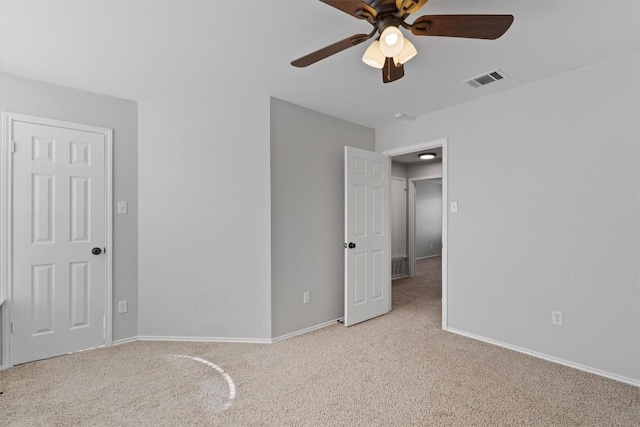 unfurnished bedroom with visible vents, baseboards, light colored carpet, and a ceiling fan