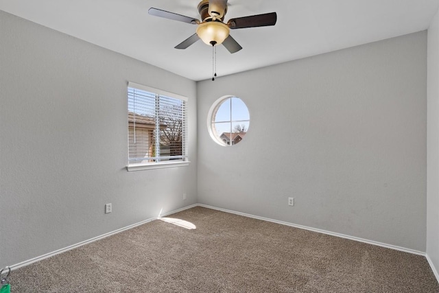 empty room featuring baseboards, carpet floors, and a ceiling fan