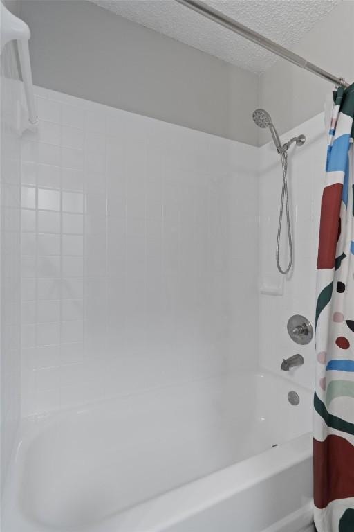 full bathroom with a textured ceiling and shower / bath combo