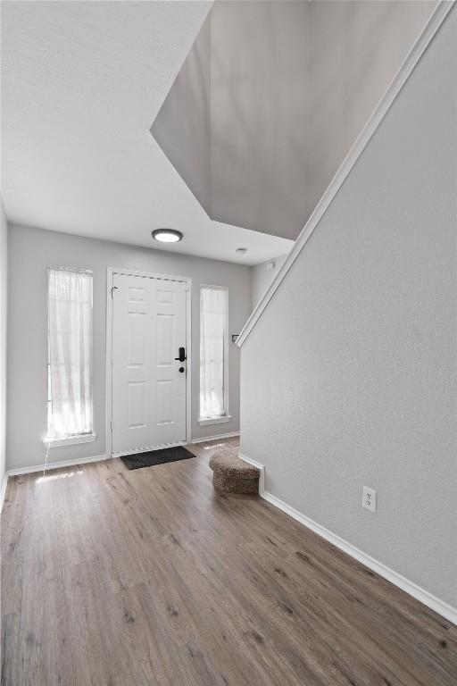 foyer with baseboards and wood finished floors