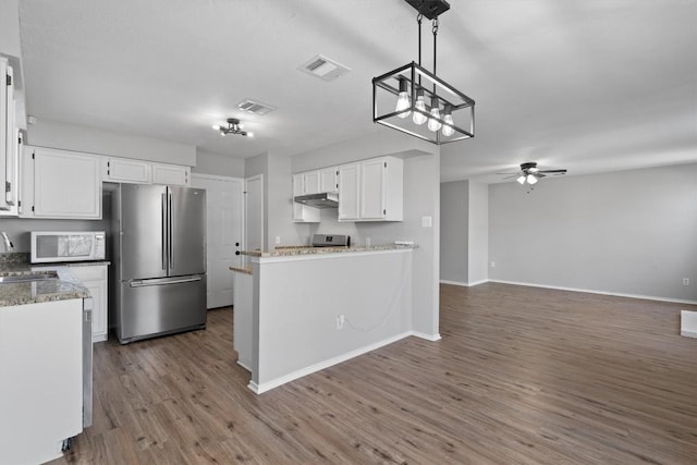 kitchen featuring visible vents, under cabinet range hood, ceiling fan with notable chandelier, appliances with stainless steel finishes, and white cabinets