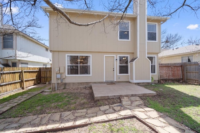 back of property with a lawn, a fenced backyard, and a patio area