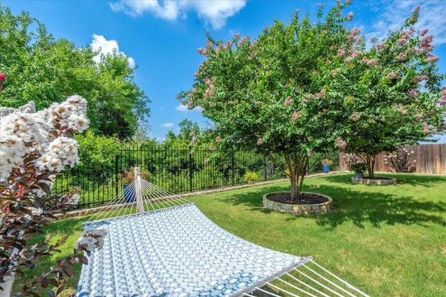 view of property's community with fence and a lawn