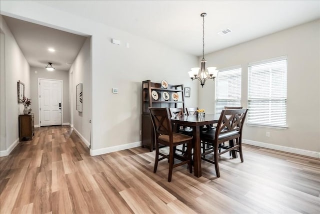 dining room featuring an inviting chandelier, light wood-style floors, visible vents, and baseboards