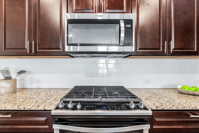 kitchen featuring backsplash, stainless steel appliances, light stone counters, and dark brown cabinetry