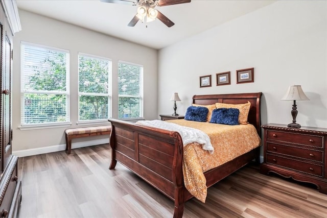 bedroom with wood finished floors, baseboards, and ceiling fan