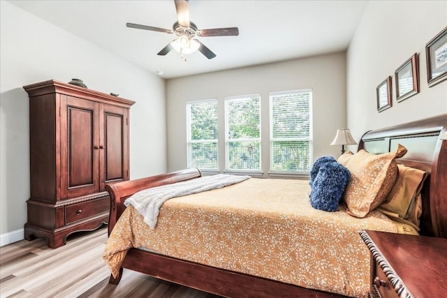 bedroom with baseboards, ceiling fan, and wood finished floors