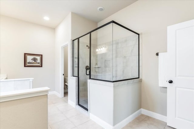 bathroom with a shower stall, recessed lighting, baseboards, and tile patterned floors