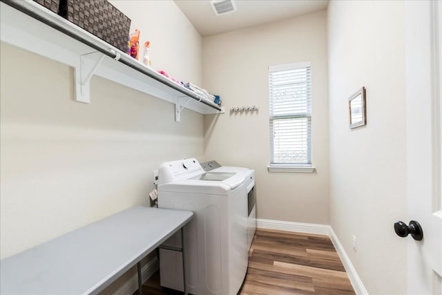 washroom with visible vents, baseboards, laundry area, light wood-style flooring, and separate washer and dryer