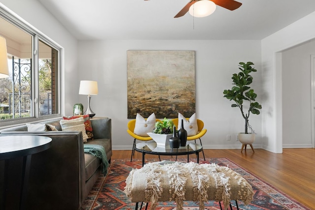 sitting room featuring wood finished floors, baseboards, and ceiling fan