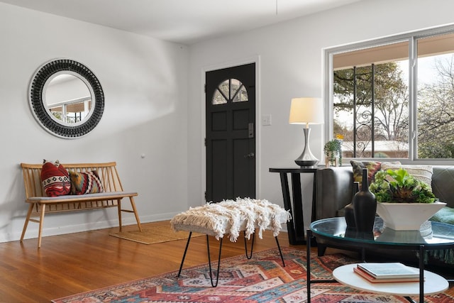 foyer featuring baseboards and wood finished floors