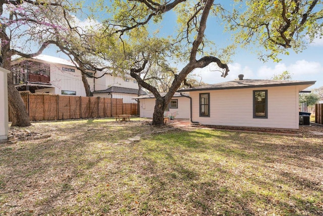 rear view of property with a yard and fence