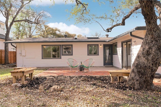 rear view of property with a patio and fence