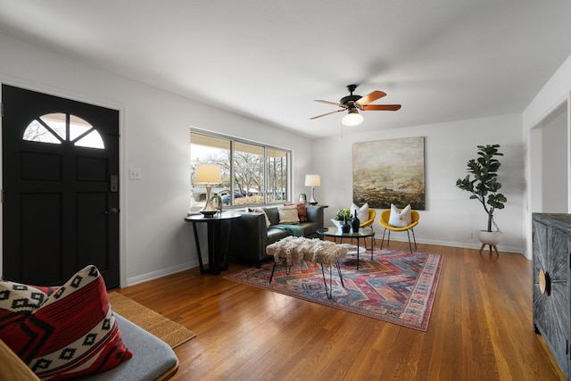 living area with ceiling fan, baseboards, and wood finished floors