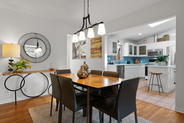 dining area featuring vaulted ceiling, recessed lighting, and light wood-type flooring