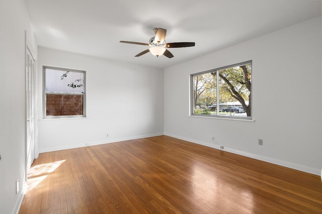 empty room with hardwood / wood-style floors, baseboards, and ceiling fan