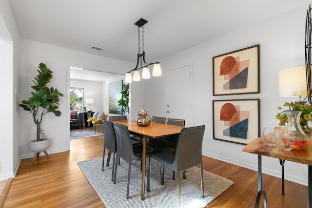 dining area with visible vents, baseboards, and light wood-style floors