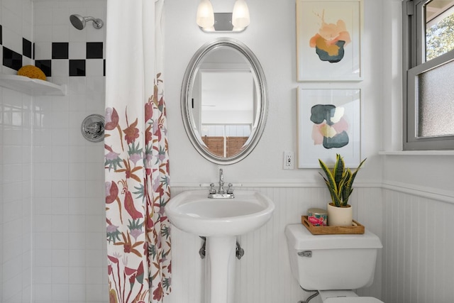 full bath featuring a wainscoted wall, toilet, and a shower with shower curtain