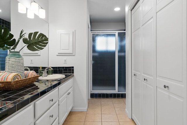 full bathroom featuring tile patterned flooring, a shower stall, vanity, and baseboards