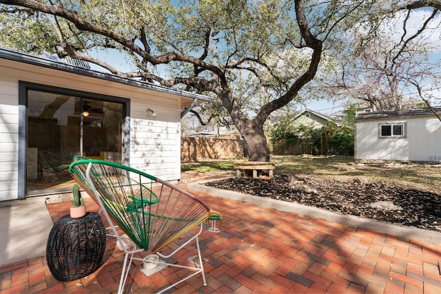 view of patio featuring an outbuilding and fence