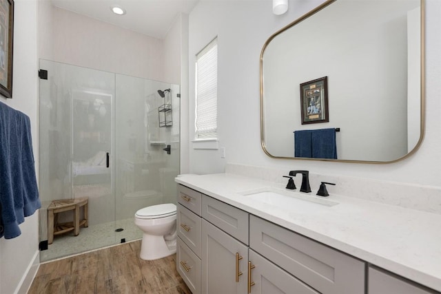 full bath with vanity, a shower stall, toilet, and wood finished floors