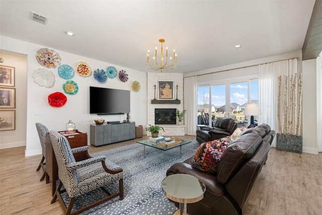 living room featuring visible vents, baseboards, light wood-style floors, and an inviting chandelier