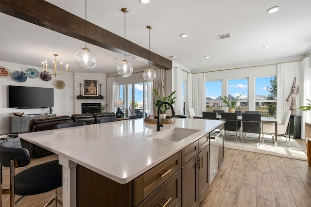 kitchen with dishwasher, open floor plan, visible vents, and a sink