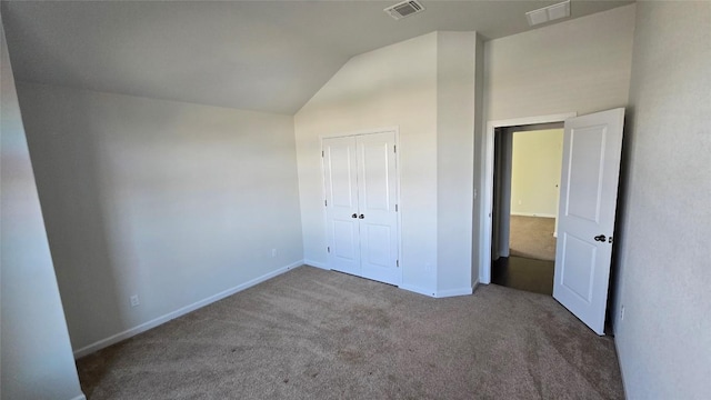 unfurnished bedroom featuring visible vents, baseboards, carpet, and vaulted ceiling