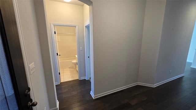 hall with baseboards and dark wood finished floors