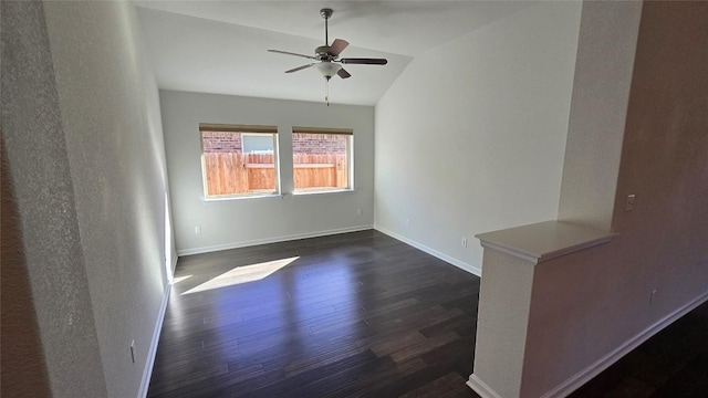 unfurnished room featuring dark wood-style floors, baseboards, ceiling fan, and vaulted ceiling