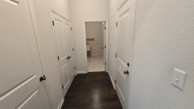 hall featuring dark wood finished floors and baseboards