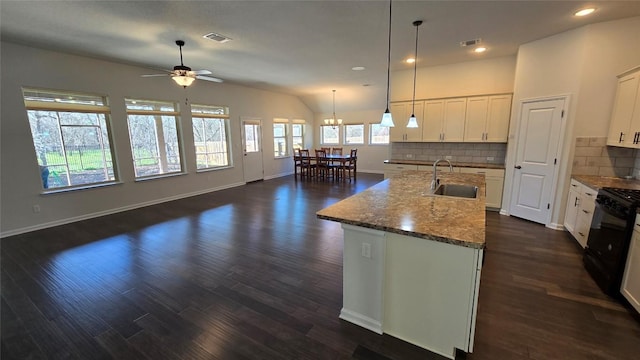 kitchen with tasteful backsplash, black range with gas stovetop, dark wood-type flooring, ceiling fan with notable chandelier, and a sink