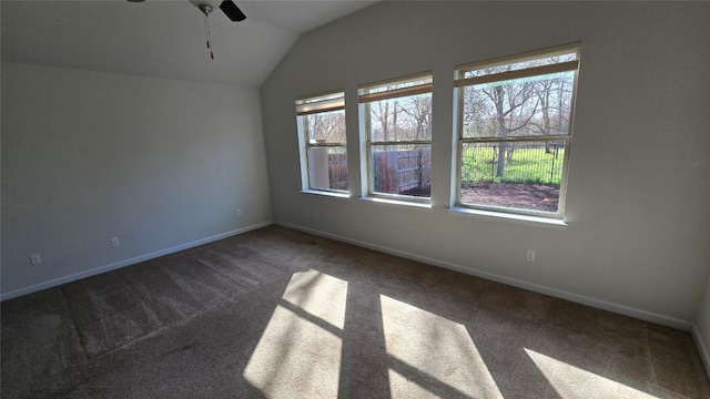 unfurnished room with lofted ceiling, baseboards, dark colored carpet, and ceiling fan