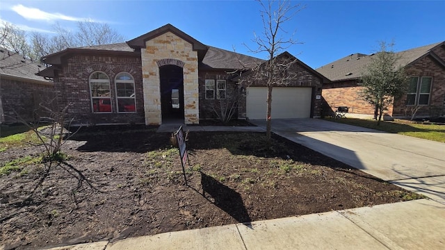 french provincial home with stone siding, concrete driveway, a shingled roof, a garage, and brick siding