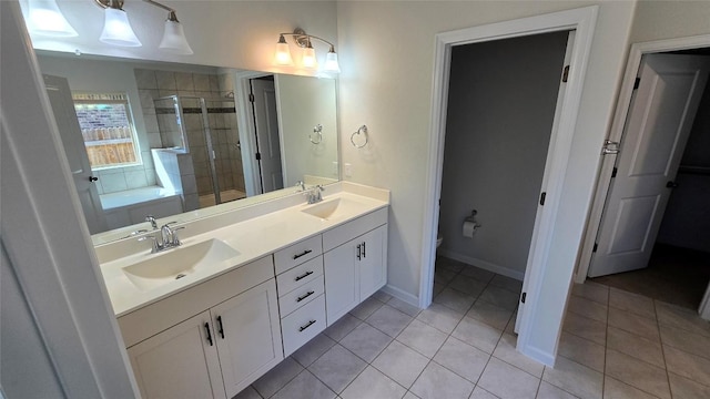 bathroom featuring tile patterned floors, toilet, a stall shower, and a sink