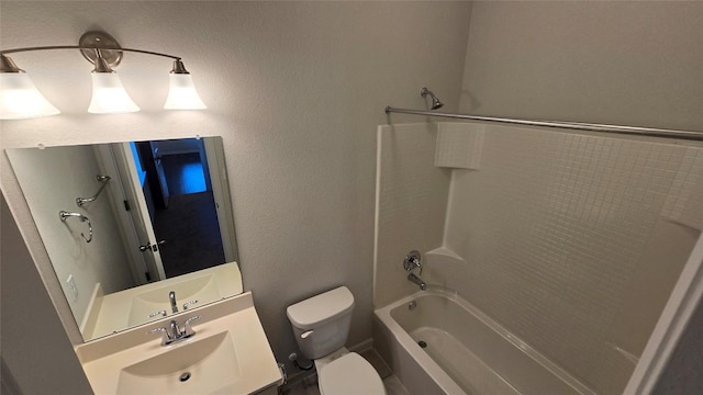 full bath with vanity, toilet, shower / bathing tub combination, and a textured wall