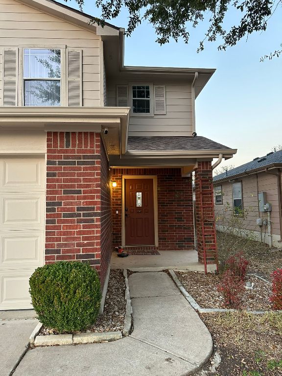 doorway to property featuring brick siding