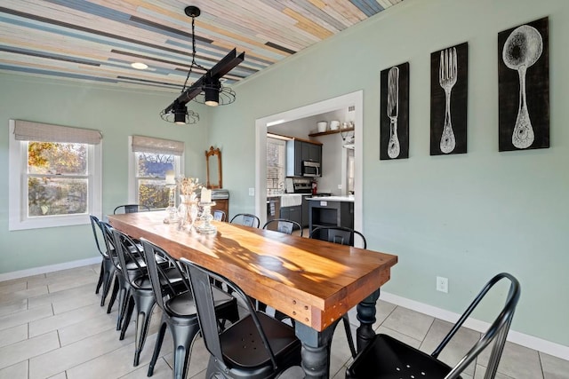 dining area with baseboards, wood ceiling, and light tile patterned flooring