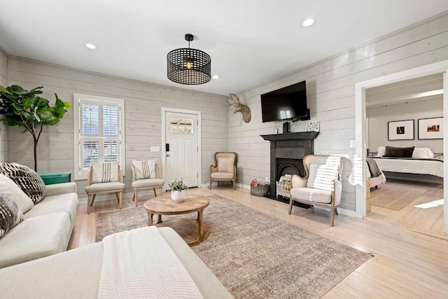 living room with a fireplace with flush hearth, recessed lighting, and wood finished floors