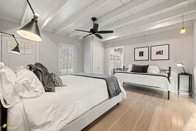 bedroom featuring a closet, beamed ceiling, ceiling fan, and wood finished floors