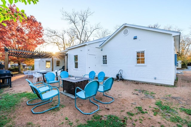 back of property with a patio area, a pergola, and an outdoor fire pit