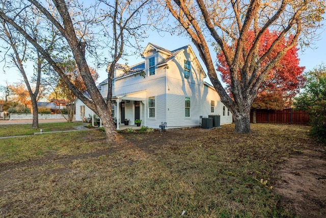 view of home's exterior featuring a lawn, central AC unit, and fence