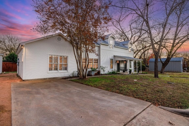 view of front of property with a lawn, concrete driveway, a patio, and fence