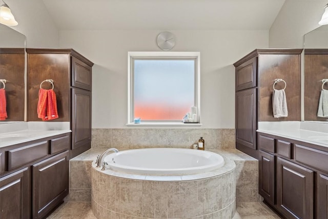 full bathroom featuring two vanities and a bath