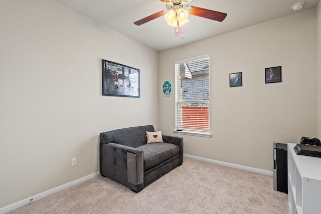 sitting room featuring light carpet, baseboards, and ceiling fan