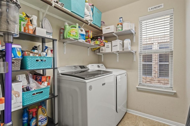 clothes washing area with laundry area, baseboards, and washing machine and clothes dryer