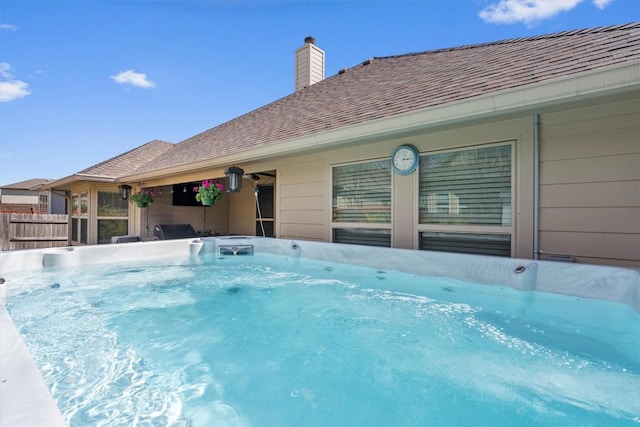 view of pool featuring a hot tub and fence