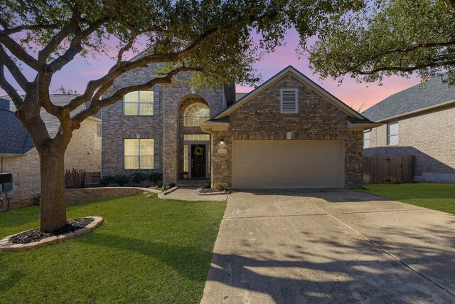 traditional-style house featuring concrete driveway, brick siding, and a garage