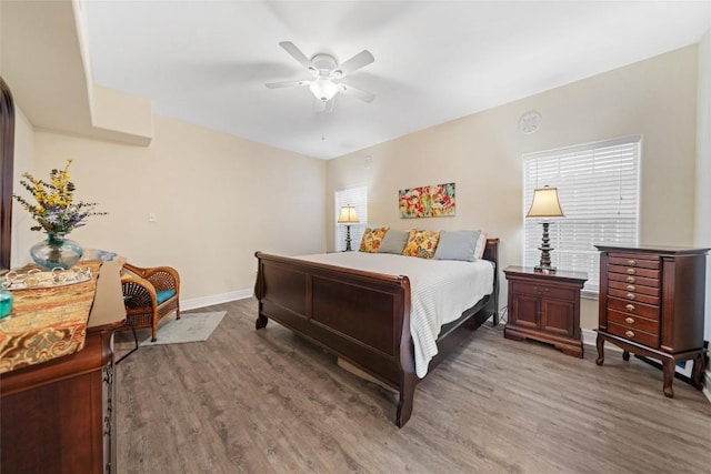 bedroom featuring light wood-style floors, baseboards, and ceiling fan